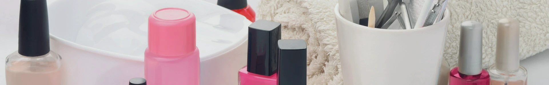 Zestaw akcesoriów do stylizacji paznokci, takich jak lakiery, pędzle i pilniki, ustawionych na blacie w salonie kosmetycznym